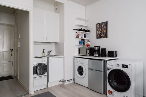 This thoughtfully designed kitchen may be small, but it’s fully equipped with all the essentials—from a stovetop and fridge to cookware, utensils, and a coffee maker.