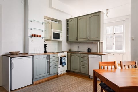 The kitchen features sleek cabinetry, quality cookware, and all the essential appliances—including a stove, oven, fridge, microwave, and kettle.