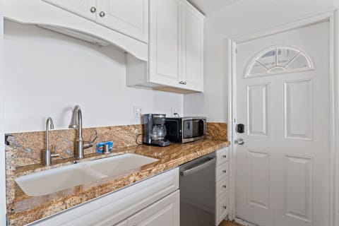 Compact kitchen with granite countertops and direct outdoor access.