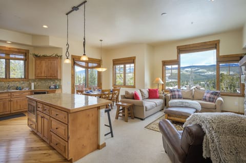 - Open concept living area blends kitchen dining and lounge with mountain views - Plush seating and warm décor create a welcoming space for families and friends - Large windows brighten the room with natural light and scenic backdrops