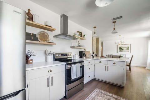 The kitchen is equipped with a sleek flat top cook range, offering a smooth surface that's easy to clean and perfect for preparing delicious meals.