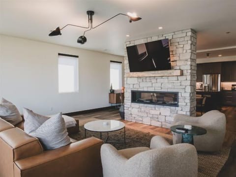 The pass-through fireplace connects the modern living room & dining area | Main Level
