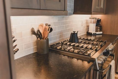 The fully equipped kitchen features an oversized island and high-end appliances| Main Level