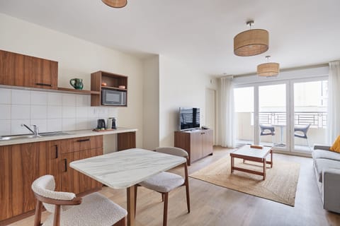 Bright open-plan apartment with a fully equipped kitchenette, perfect for enjoying home-cooked meals just minutes from Paris.