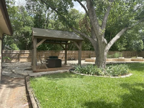 Large back yard with covered table and propane grill