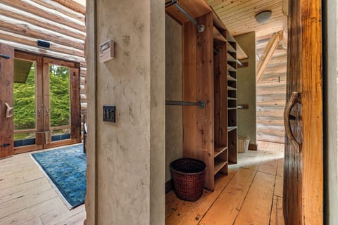 Stunning walk-in closet blends luxury with rustic log home charm.