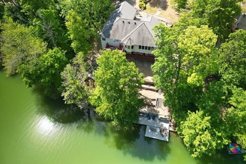 Bird’s-eye view of your private lakefront home and dock on Loch Lomond, tucked amid lush trees.