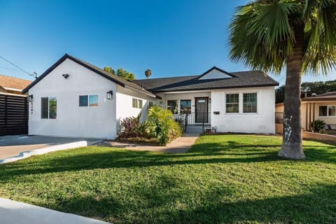 Charming white house with black roof and inviting porch