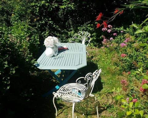 graden table and chairs with vase and glasses, with flowers surrounding