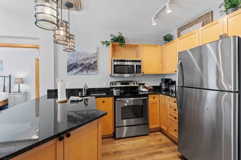 The full kitchen features stainless steel appliances, and breakfast bar seating 3.