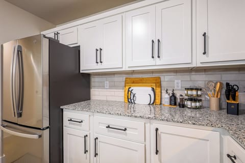 Fully equipped kitchen with cutting boards, spices, and utensils.