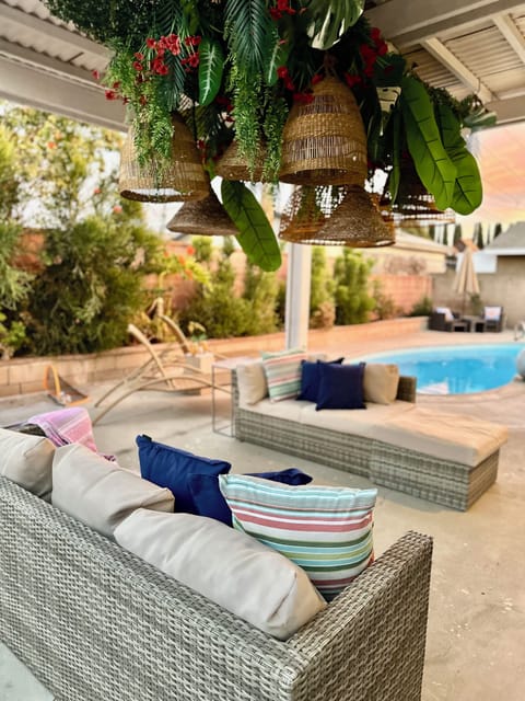 A serene outdoor lounge with lush greenery and a sparkling pool for unwinding.