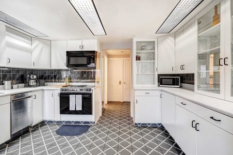 Whip up meals with ease in this bright, fully equipped kitchen featuring modern appliances, ample counter space, and classic cabinetry.