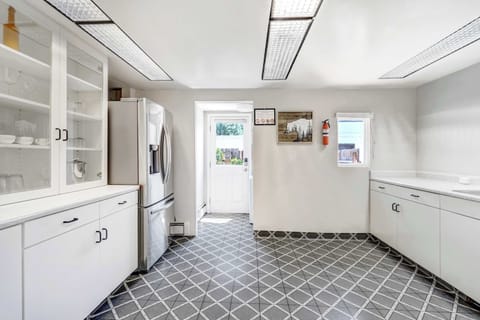 Whip up meals with ease in this bright, fully equipped kitchen featuring modern appliances, ample counter space, and classic cabinetry.