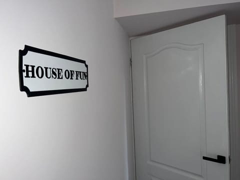 "HOUSE OF FUN" sign by a white door