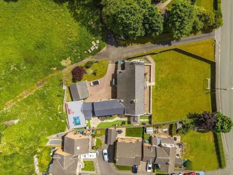 Picturesque aerial view of a charming house with a lush green yard and nearby pool!