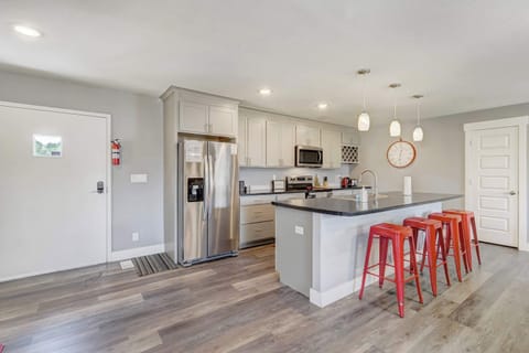 Fully equipped kitchen with stainless steel appliances, ample counter space, and vibrant bar seating for casual dining








