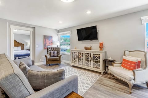 Spacious open-concept living area with cozy seating, a Smart TV, and large windows framing mountain views