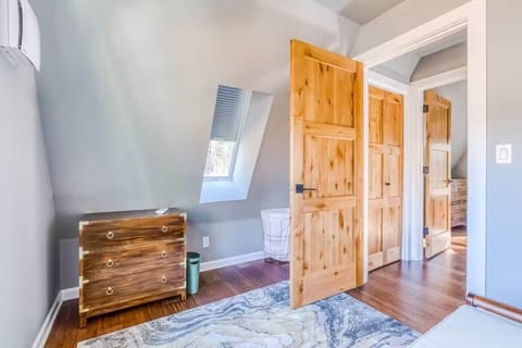 right and airy bedroom with slanted ceilings, skylight, and warm wood accents—clean, simple, and perfect for a peaceful stay.