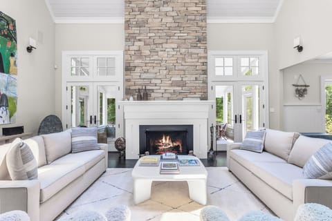 Soaring ceilings, sleek sofas, and a glowing stone fireplace.