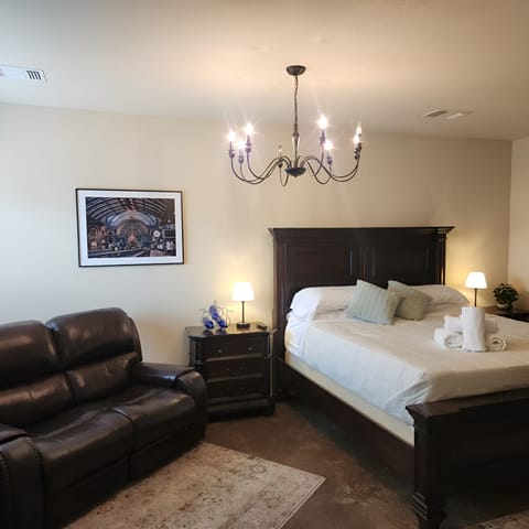Elegant Suite: Experience charm with a king bed, leather seating, and stylish chandelier lighting!