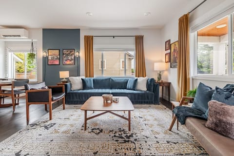 Bright & Inviting – A sunlit living space with plush seating, Smart TV, and cozy design details.