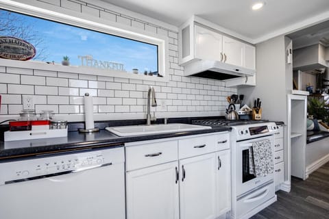 Galley Kitchen that features a gas stove/oven, dishwasher, microwave, full-sized fridge, and Keurig coffee maker.