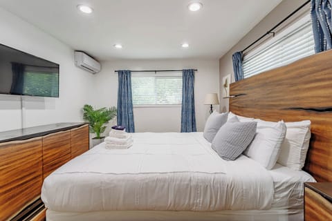 Main Bedroom of the home with wood accents. Cal King Bed w/ Roku Smart TV.