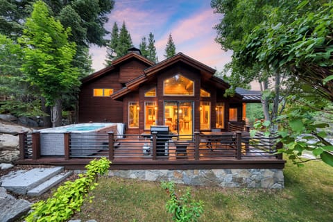 Spacious exterior deck featuring a private hot tub, grill, and outdoor dining area