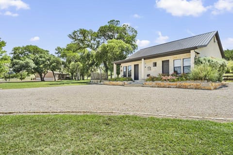 Discover your serene retreat! This charming vacation rental boasts a spacious gravel driveway, surrounded by lush greenery and mature trees, offering a peaceful escape with ample space