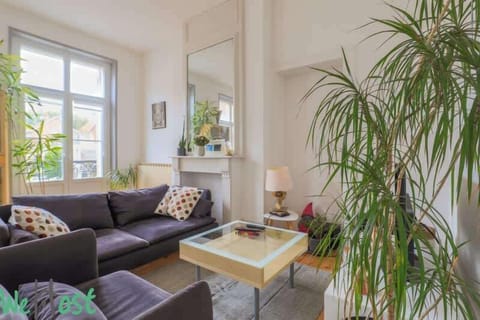 Salon avec canapé et fauteuil, accès à la terrasse, télévision