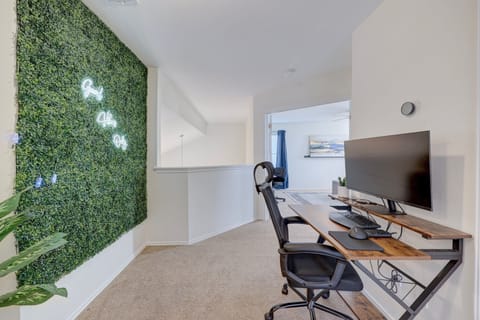Your productivity just found its happy place. This upstairs loft office features a lush greenery wall with neon “Good Vibes Only” lighting and a sleek setup perfect for remote work or creative bursts.