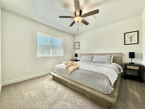 Bedroom 2 features a plush king sized bed, ceiling fan, night stands, and closet