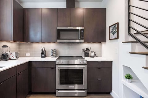 Cook with ease in this stylish kitchen featuring deep wood cabinets and stainless steel appliances.