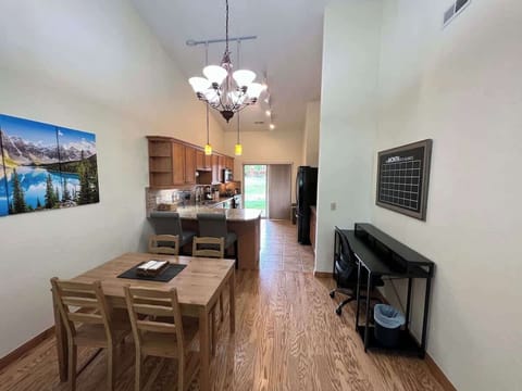 View from dining area to kitchen, seating for 6 people, and work station.