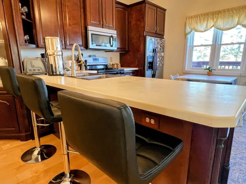 open kitchen, bar, dining room, kitchen table, & door to your porch