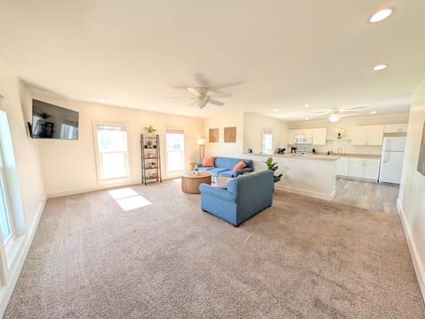 Large, open living space with plenty of seating, modern decor and a large Roku Smart TV