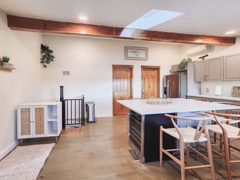 Vaulted ceiling and open kitchen space. Spiral staircase leads downstairs