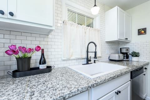 Granite countertops, subway tile backsplash, and farmhouse sink.
