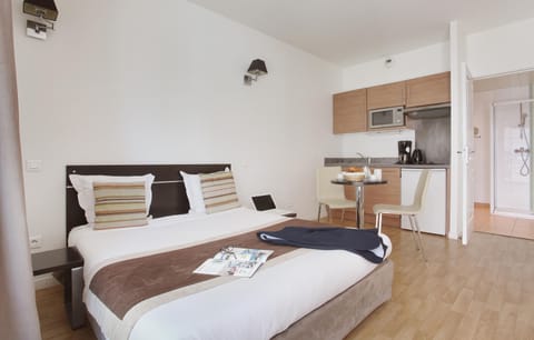 Unwind in a roomy studio with a comfortable bed, seating area, and fully equipped kitchenette — ideal for small families or friends.