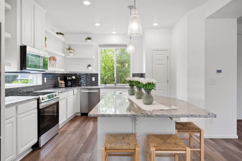 Bright kitchen with granite, stainless steel appliances, and cozy seating.