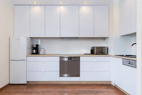 Modern kitchen with fridge with freezer, oven, coffee machine and microwave.