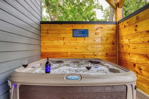 Unwind in the bubbling hot tub under string lights, sip your favorite drink, and soak in the privacy of Bearfoot Getaway's secluded back deck.