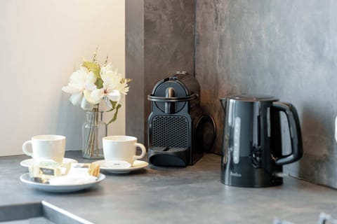 A dedicated corner with a coffee machine, electric kettle, cups, and decorative flowers – ideal for a quick morning pick-me-up or evening tea.