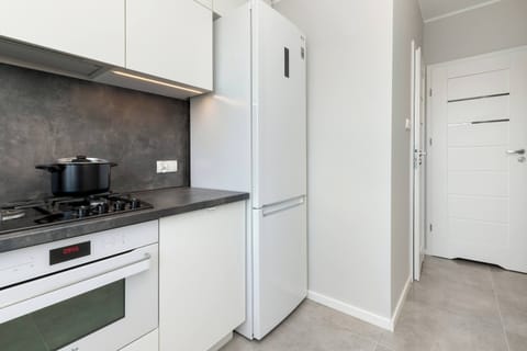 A modern, fully equipped kitchen with white cabinetry and built-in appliances.
