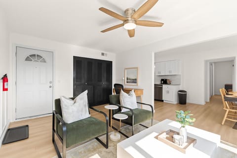 Open-concept living and dining area with ceiling fan, stylish accents, and plenty of natural light.