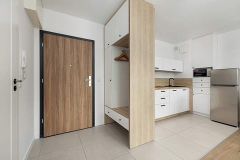The view of the kitchen from the bright spacious hallway, with a large closet, shows the full equipment, which combines functionality with aesthetics.