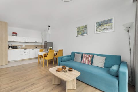 Another corner of the living room presents an elegant dining table and a cozy seating area with a sofa and a modern coffee table, ideal for evening relaxation.