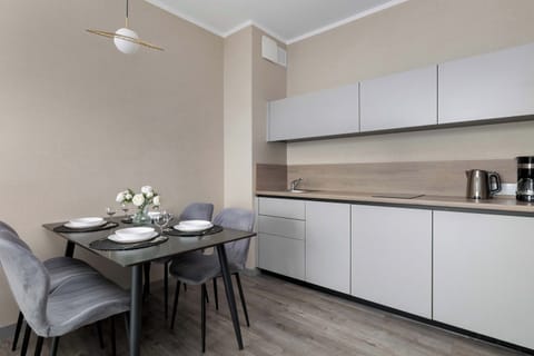 A modern kitchen with white cabinetry and an elegant dining area. The setup is both stylish and practical for everyday use.