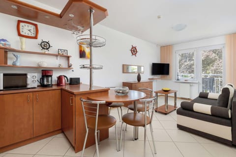 Fully equipped kitchenette with dining area and living room with sofa nad TV.